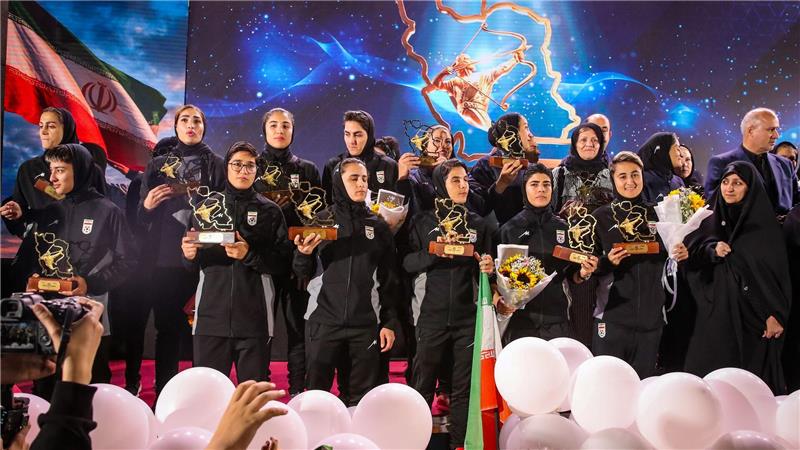 Spielerinnen der iranischen Fußball-Nationalmannschaft stehen auf einer Bühne in Teheran, während einer Empfangszeremonie nach ihrer Teilnahme am AFC Women’s Asian Cup in Australien.