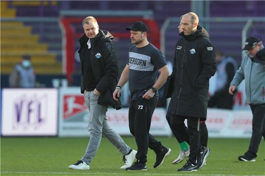 Sportgeschäftsführer Fabian Wohlgemuth (l-r), Trainer Steffen Baumgart und Co-Trainer Daniel Scherning aus Paderborn gehen über das Spielfeld.