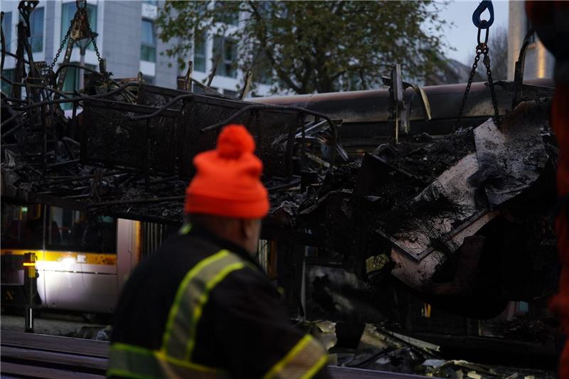 „Schande über Irland gebracht”: Krawalle erschüttern Dublin Spuren der Ausschreitungen in Dublin. Ein Arbeiter steht vor einer ausgebrannten Straßenbahn.