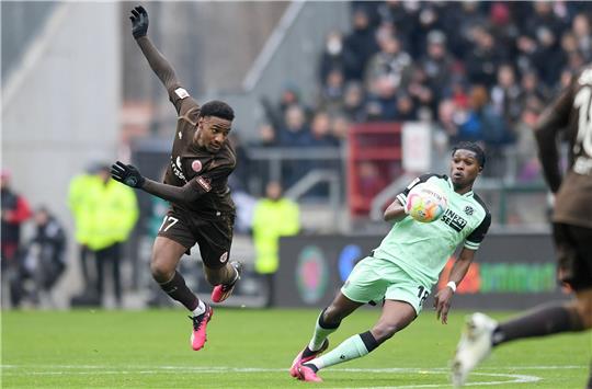 St. Paulis Oladapo Afolayan (l) und Hannovers Derrick Köhn kämpfen um den Ball.