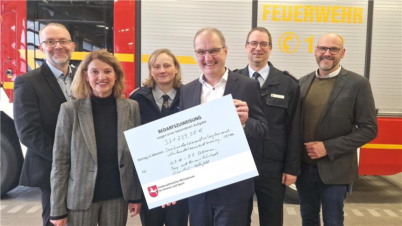 Hoher Zuschuss aus dem Land für neues Feuerwehrauto in Altenau Staatssekretär Stephan Manke (3.v.r) hat viel Geld für die Altenauer Feuerwehr dabei. Über den Scheck freuen sich (v.l.): Kämmerer Michael Strübig, Bürgermeisterin Petra Emmerich-Kopatsch, Ortsbrandmeisterin Anna-Katharina Ehrenberg, Stadtbrandmeister Markus Finck und der SPD-Landtagsabgeordnete Alexander Saade.