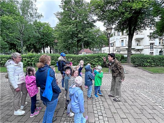 Stadtführerin Monika Franz legt sich mächtig ins Zeug, um ihren kleinen Gästen die Sehenswürdigkeiten und die Geschichte der Stadt näherzubringen. Sie erzählt beispielsweise, dass es in der Radauburg (im Hintergrund) einmal ein Kino gegeben hat. Foto: Schlegel