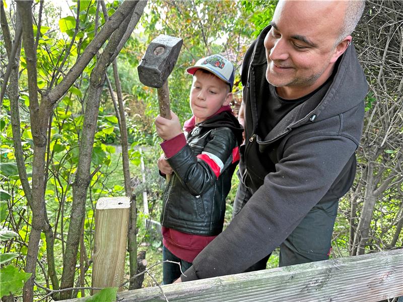Stadtjugendpfleger Florian Hinz hilft beim Einschlagen der Bodenhülsen für die Gartenpforte. Foto: Schlegel