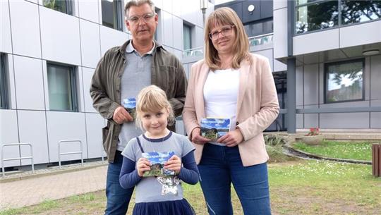 Stadtjugendpfleger Jens Fiebig und Ferienpass-Koordinatorin Anja Magerl von der Stadtjugendpflege präsentieren mit der sechsjährigen Pia Fehse das druckfrische Produkt.
