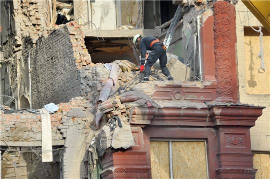 Städtische Arbeiter räumen Trümmer aus einem Wohnhaus, das am 18.10.2023 von einer Rakete getroffen wurde.