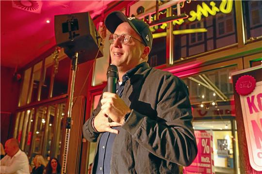 Stand-up-Comedian Benni Stark steht auf der Bühne im Restaurant „Tim‘s“. Foto: Schönfisch