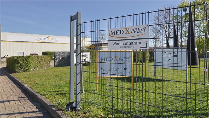 Eingangstor mit mehreren Schildern der Firma MED X PRESS und Hinweis zur Warenannahme