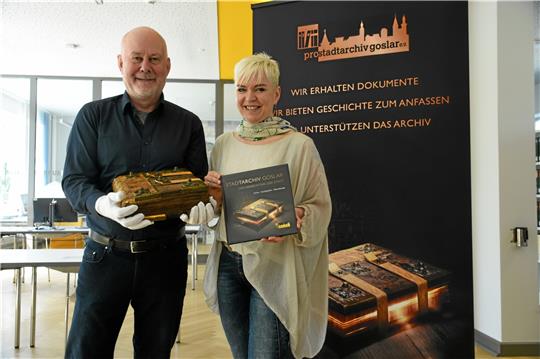 Starke Stütze(n): Thomas Jürgens vom Förderverein „pro Stadtarchiv“ und Cora Abler (Krododesign) präsentieren im Mai 2023 die Geschichte des Stadtarchivs als Buch mit 166 Seiten. Auf dem Titel ist das Stadtrecht von 1350 abgebildet. Archivfoto: Kempfer