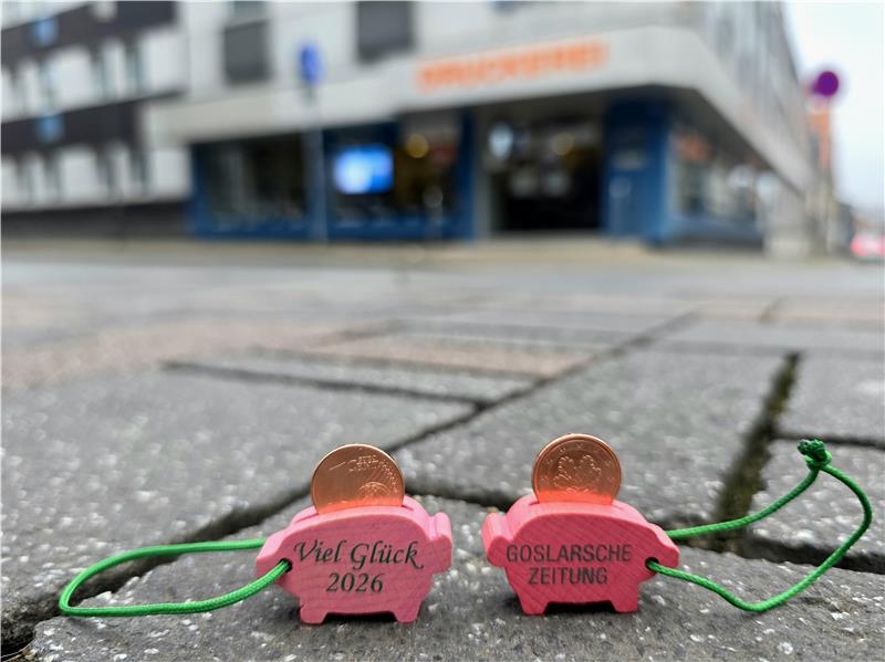 Zwei GZ-Glücksschweinchen stehen in der Fußgängerzone.