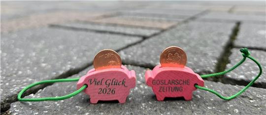 Zwei GZ-Glücksschweinchen stehen in der Fußgängerzone.