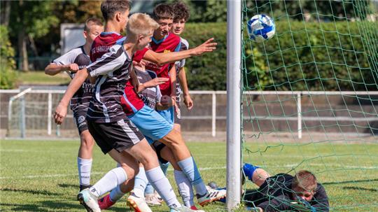 Stefan Tubic (2. v. l.) von den C-Junioren der JSG Langelsheim stochert den Ball aus dem Gewühl heraus zum 1:0 gegen Petershütte über die Linie. TuSpo-Keeper Leon Maurice Marzadek ist geschlagen.