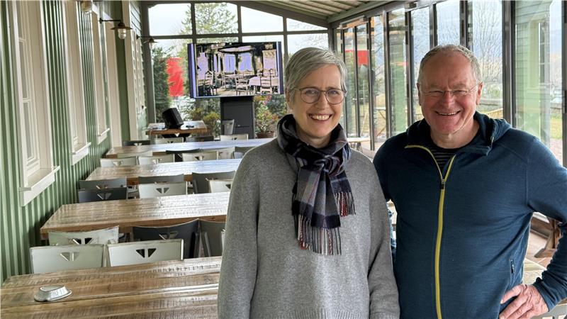 Das Foto zeigt ein fröhliches Paar in einem Wintergarten.