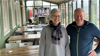 Das Foto zeigt ein fröhliches Paar in einem Wintergarten.