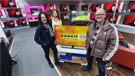 Steffen Ehbrecht (r.) freut sich über das Bundle aus TV und Soundbar, mit ihm freuen sich Franziska Jackowicz von der GZ und Sybille Truskaller von expert.