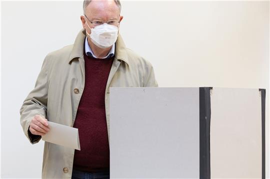 Stephan Weil (SPD) steht mit seinem ausgefüllten Stimmzettel in einer Wahlkabine.