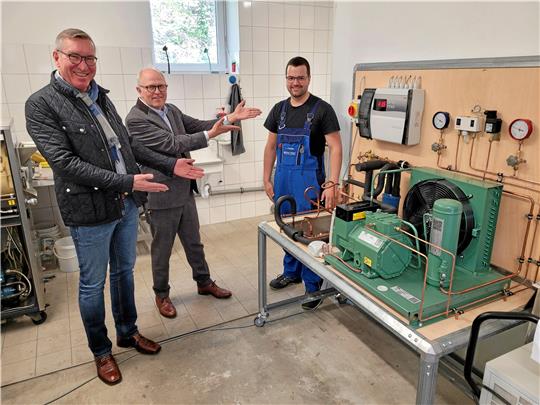 Stiftungsvorsitzender Bernd Giesel und Rotary-Präsident Dirk Junicke (v.l.) haben mit Frederik Stiegen ihren Preisträger für 2023 gefunden. Neben dem Schlewecker die Eisbahn-Maschine, mit der er bei der Berufe-WM Vierter geworden ist.  Foto: Exner