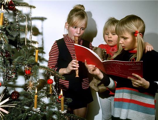 „Stille Nacht“ unterm Weihnachtsbaum: Musizieren und Gedichte gehörten früher zum Familienfest an Heiligabend. Heute ist es Heiligabend zu Hause bei vielen ziemlich still geworden. Symbolfoto: dpa