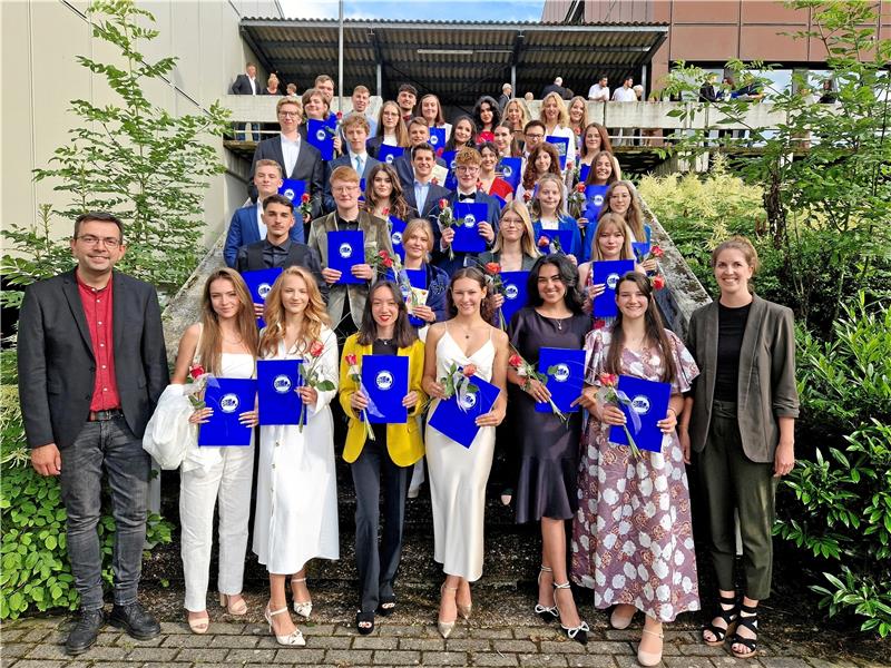 Abitur: Robert-Koch-Schüler sind 13 Jahre im falschen Film Stolz hält der Abiturjahrgang der RKS seine Abschlusszeugnisse in den Händen. Umrahmt werden die jungen Erwachsenen von ihren Tutoren Stefan Klockgether und Patricia Hiller. Foto: Knoke