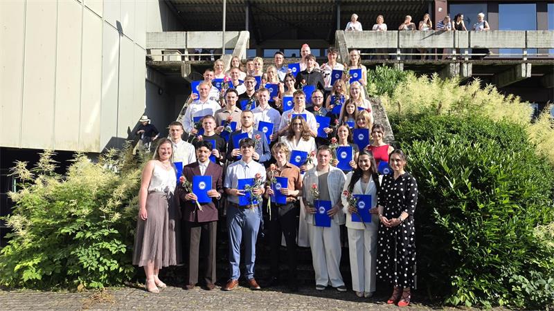 Stolz halten die Absolventinnen und Absolventen der Robert-Koch-Schule ihre Abiturzeugnisse in den Händen.