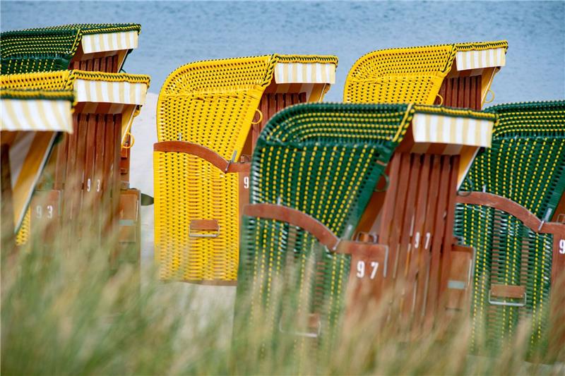 Tourismuswirtschaft mit gedämpften Erwartungen an 2024 Strandkörbe stehen bei sonnigem Wetter am Strand auf der Insel Rügen.