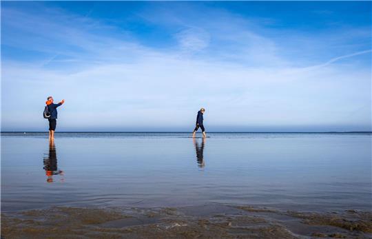 Strandspaziergänger sind an der Ostsee am Wohlenberger Wieck unterwegs.