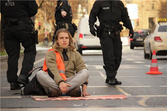 Straßenblockade in München: Bei der Störaktion klebte sich Leander (21) im Dezember auf eine Hauptverkehrsstraße. Foto: Jonas Lein