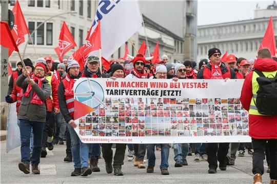 Streikende Mitarbeiter des Windanlagenherstellers Vestas ziehen mit einem Transparent durch die Hamburger Innenstadt.