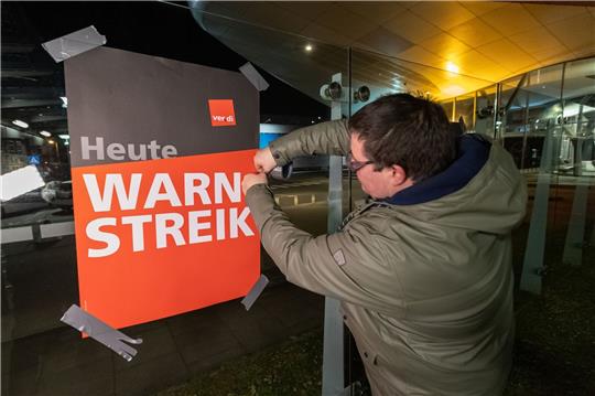 Streikende hängen Plakate mit der Aufschrift «Warnstreik» bei der Lufthansa Technik auf. Mit erneuten Warnstreiks gleich mehrerer Berufsgruppen legt die Gewerkschaft Verdi am Donnerstag und Freitag wichtige Teile des deutschen Luftverkehrs lahm.