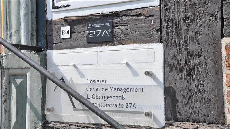 Hausfassade mit Schild 'Goslarer Gebäude Management 1. Obergeschoß Ventorstraße 27A' und schwarzem Türschild '27A'