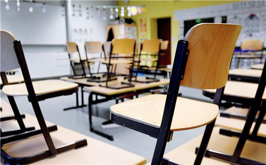 Stühle stehen in einem Klassenzimmer in einer Grundschule auf den Tischen. (Symbolbild)