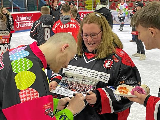 Stürmer André Gerartz, der zuletzt angeschlagen gespielt hat, unterschreibt im Ostereier-Trikot bei Fans. Foto: Heine