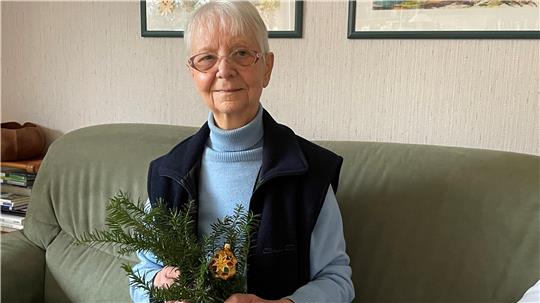 Susanne Mauch hat eine verzierte goldene Weihnachtsbaumkugel bis heute bewahrt, die sie an ihre Kindheit erinnert.