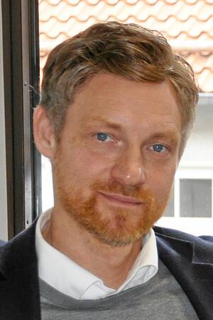 Kohl und Busse rauchen im Goslarer Schulstreit die Friedenspfeife Ein Mann mit Bart lächelt in die Kamera.