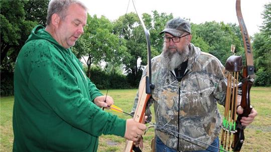 Sven Huwald (l.) lässt sich von Andreas „Andy“ Losin die Kunst des Bogenschießens erklären.
