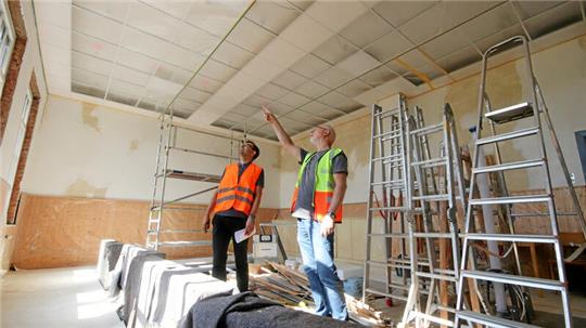 Sven Ladwig (li.) und Dieter Lühring vom Bauamt der Stadt Langelsheim inspizieren den Saal des Nauener Dorfgemeinschaftshauses.