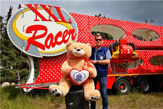 Sven Schneider mit den noch namenlosen Maskottchen des diesjährigen Schützenfestes. Die Goslarsche wird in den kommenden Tagen einen Namen für das Plüschtier suchen. Im Hintergrund steht das Karussell XXL Racer.  Foto: Epping