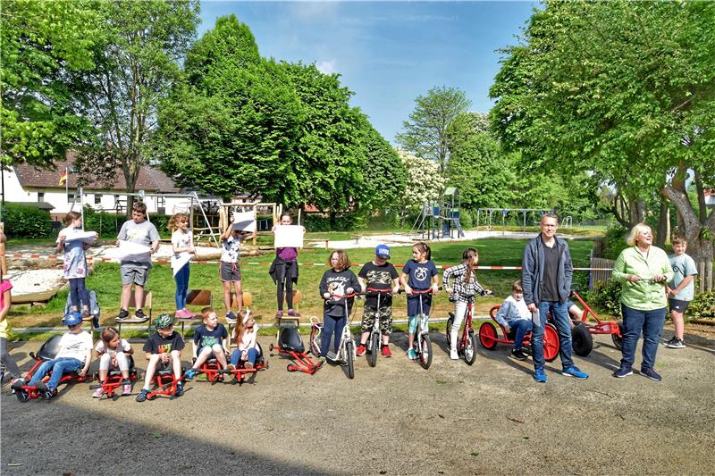 Grundschule Harlingerode feiert neu gestalteten Schulhof Swenja Niemeyer (re.) und Martin Etscheid schneiden gleich das Flatterband durch. Die Kinder nehmen derweil auf den neuen Fahrgeräten Platz. Fotos: Neumann