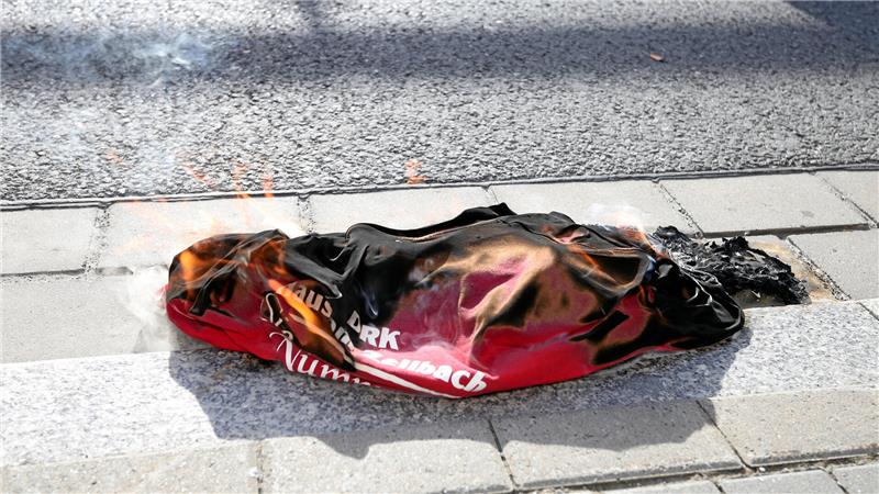 Symbol des Zorns: Kurz vor der Schließung brennt ein T-Shirt mit der Aufschrift DRK und Altenheim am Zellbach. 