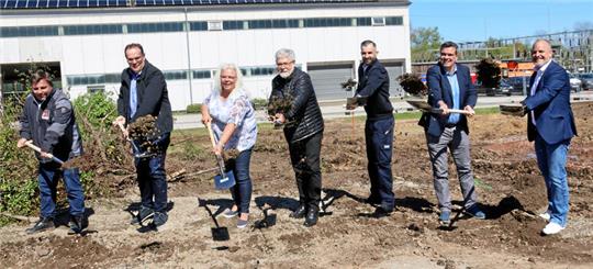 Sieben Personen bei einem symbolischen ersten Spatenstich.