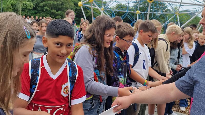 Symbolträchtige Scherenschnitte: Die früheren CvD-Klassensprecher durchtrennen farbiges Band vor den ersten Schritten ins Gebäude.