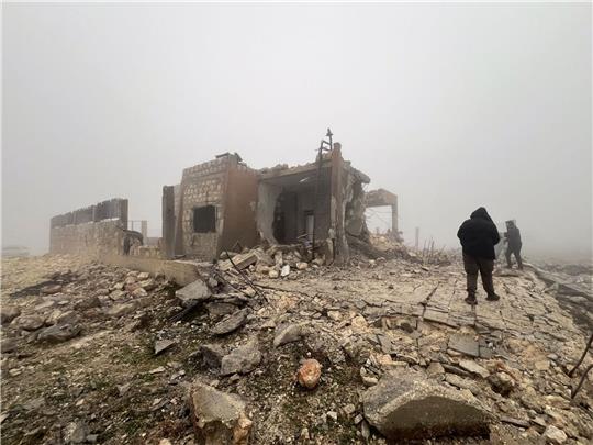 Syrer blicken auf eine verlassene medizinische Einrichtung, die nach Angaben der freiwilligen Rettungsorganisation White Helmets am späten Montagabend von iranischen Raketen getroffen wurde.