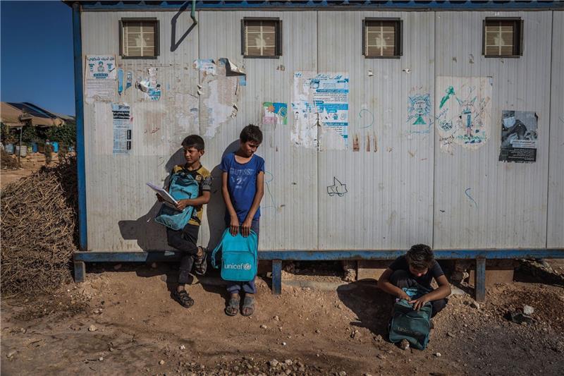 Syrische Kinder stehen neben ihrer behelfsmäßigen Schule im Lager Al-Tah für Binnenvertriebene.