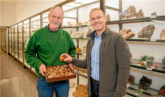 TU-Vizepräsident Prof. Christian Bohn (r.) gibt das Holzmodell eines Kristalls an Dr. Wilfried Ließmann, den Kustos der Geosammlung, weiter. Nach 50 Jahren in der Fremde war das Stück zurückgegeben worden. Foto: TU/Dell’Aquila