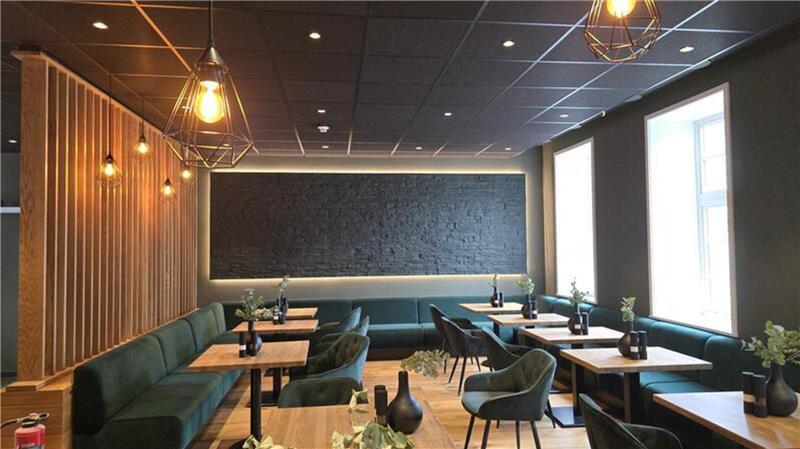 So schlägt sich das Goslarer „Schiefer“ bei „Mein Lokal, Dein Lokal“ Die Farben im "Schiefer" sind Tannengrün und Braun. Tische, Stühle und Sitzbänke im Innenraum. Auf den Tischen stehen schwarze Dekoartikel wie Vasen.