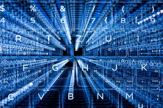 Tasten einer beleuchteten Tastatur. Befürworter sehen die Chancen von Künstlicher Intelligenz, Gegner sehen die Risiken.