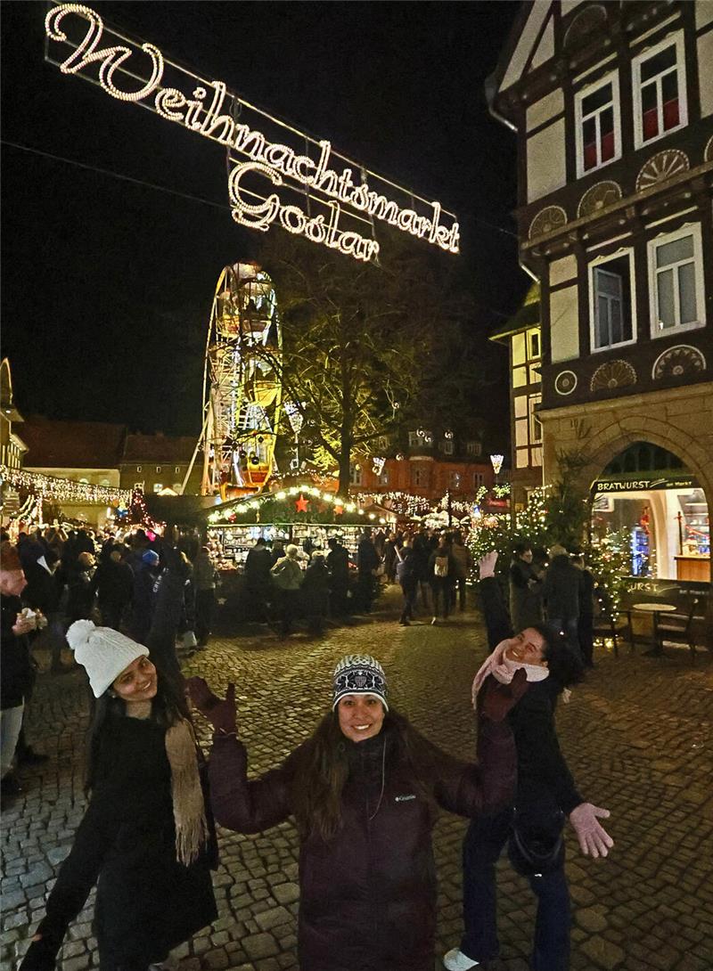Starker Start für den Goslarer Weihnachtsmarkt Drei Frauen posieren für ein Foto vor dem Goslarer Weihnachtsmarkt. Im Hintergrund ist der beleuchtete Markt zu sehen.