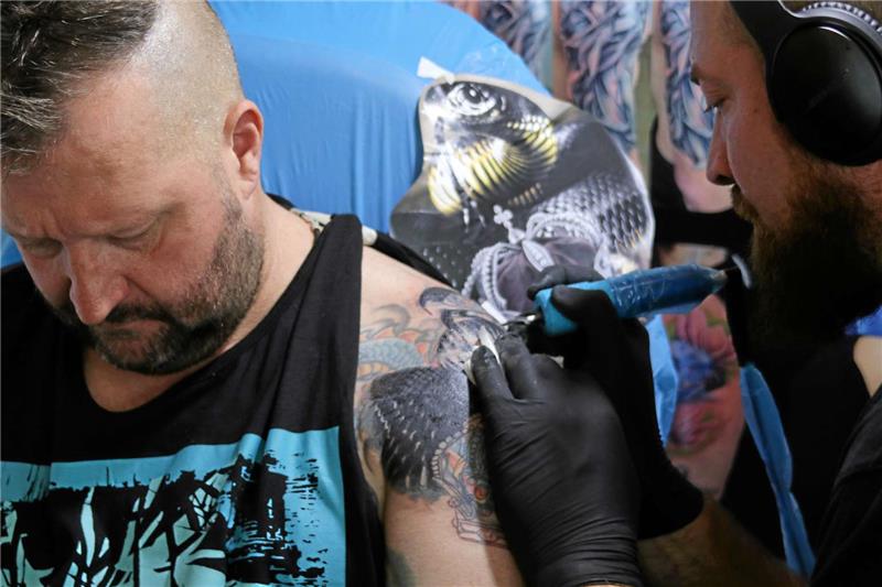 Tattoos sind für Michael Kiehl (li.) schon fast Routine. Sein neues Motiv, ein Jaguar mit Krone, soll teilweise ein altes Tattoo überdecken. Fotos: Düber