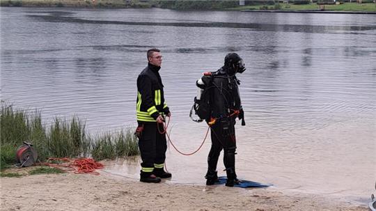 Taucher sind im Einsatz, um den vermissten Schwimmer zu finden.