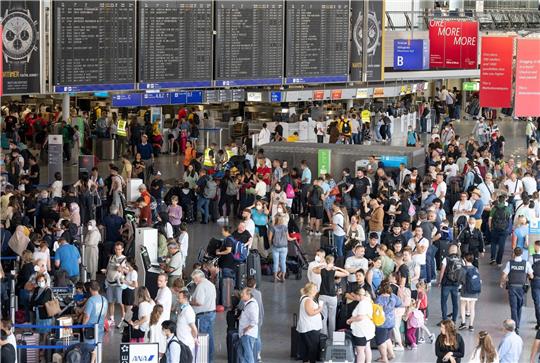 Tausende Passagiere warten vor den Abfertigungsschaltern des Flughafens auf ihren Check-In.
