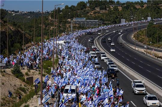 Tausende israelische Demonstranten marschieren entlang einer Autobahn, um gegen die geplante Justizreform der Regierung zu protestieren.